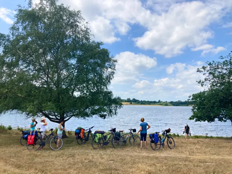 MicroAdventure: Mehrere Frauen mit Fahrrädern am See-Ufer